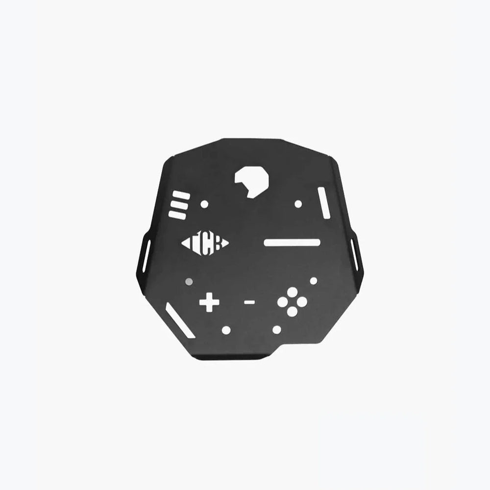 A black metal carrier plate designed for a Suzuki V Strom motorcycle, featuring cut-outs and embossed symbols for mounting accessories.