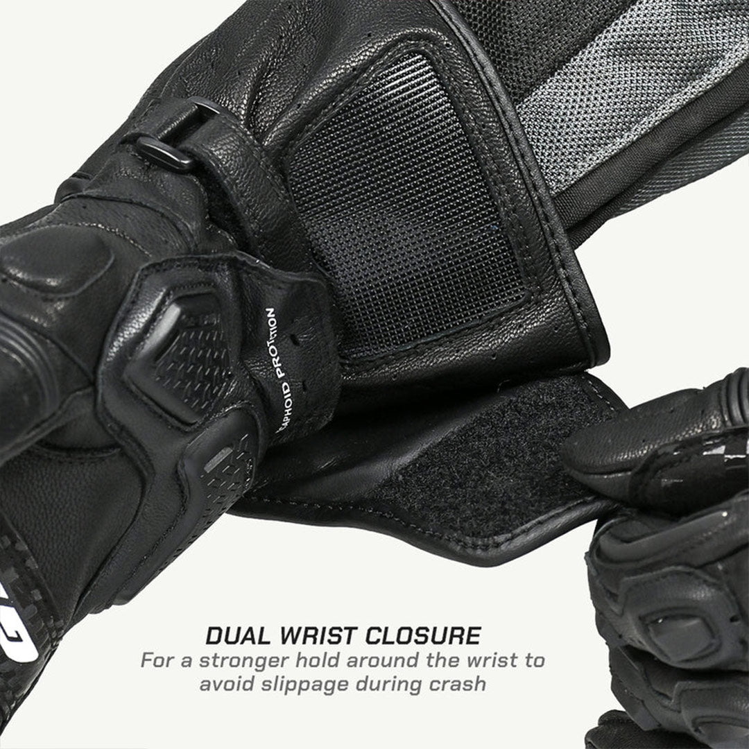 Close-up of black motorcycle gloves with dual wrist closure feature on a white background
